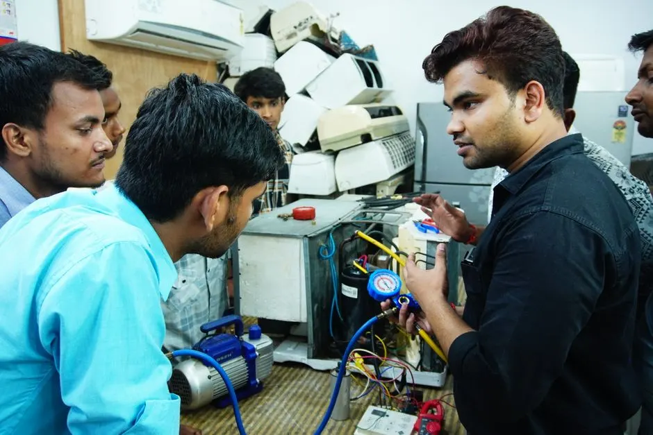 Participants learn AC repair during a hands-on session in Delhi, India.